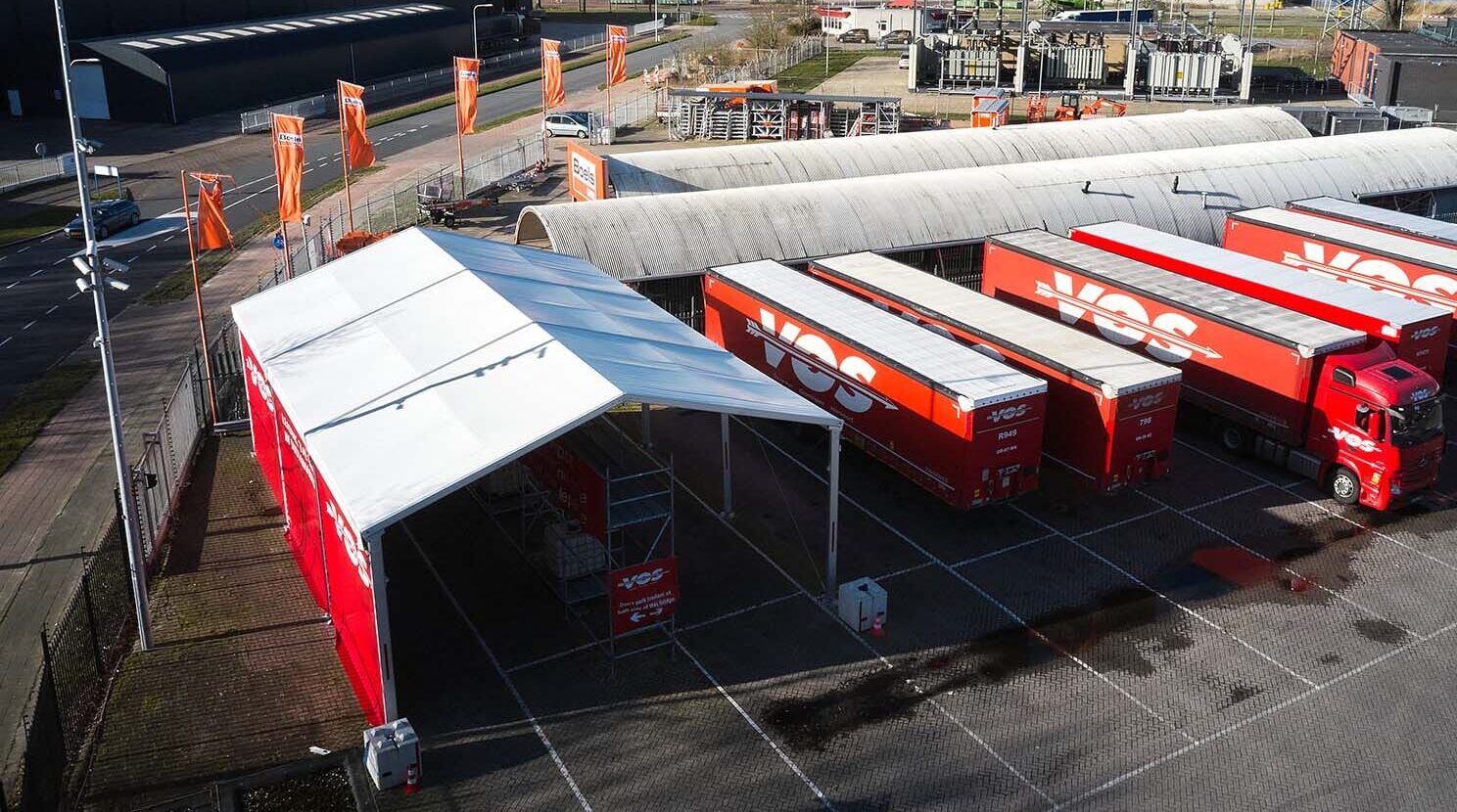 Droneshot van terrein Vos Transport met overkapping en trailers