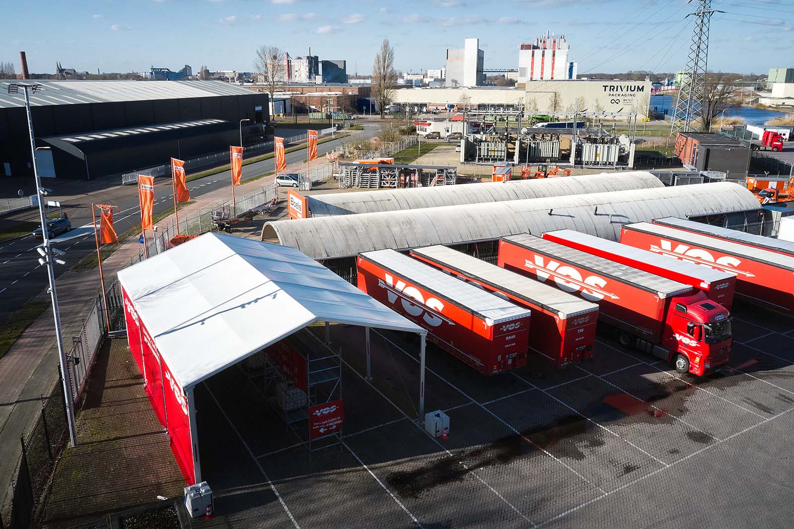 Droneshot van terrein Vos Transport met overkapping en trailers